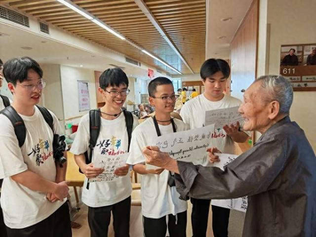 陈世明老爷爷向学子们送上自己亲笔书写的双语赠言。团台江区委供图