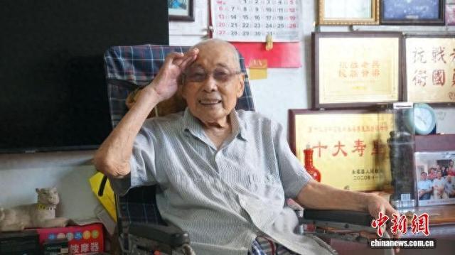 图为张云在“荣誉墙”前敬礼。莫伟雯 摄