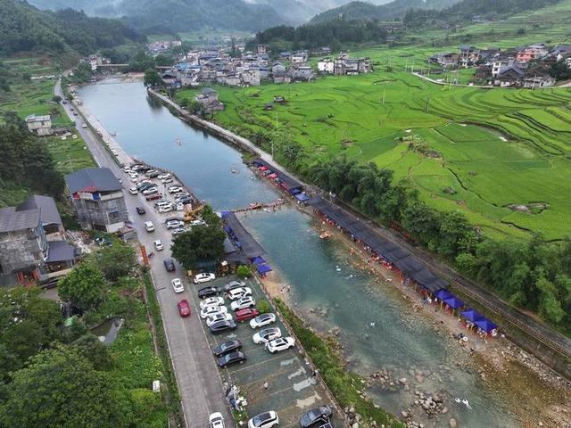游客在广西柳州市融水苗族自治县香粉乡雨卜村戏水消暑（7月19日摄，无人机照片）。新华社记者 黄孝邦 摄