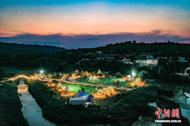 建华村露营基地绿意葱茏、溪水潺潺。 王晨 摄