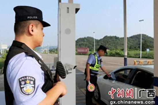 图为执勤民警为司机发放宣传扇并现场普法