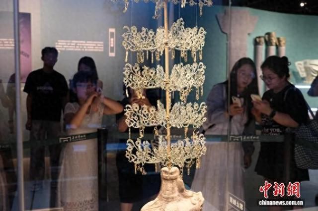8月2日，游客在浙江宁波观看三台县博物馆藏“马猴摇钱树树身”。 林波 摄