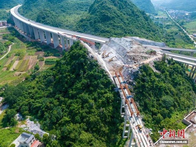 近日，广西平昭高速平乐东枢纽互通立交桥上，工程车来往穿梭，现场一派繁忙。何华文 摄