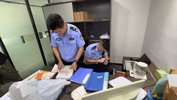 7月，成都市公安局民警查处诈骗团伙现场，两名警员正对查获的合同文件等进行取证。四川省成都市公安局供图