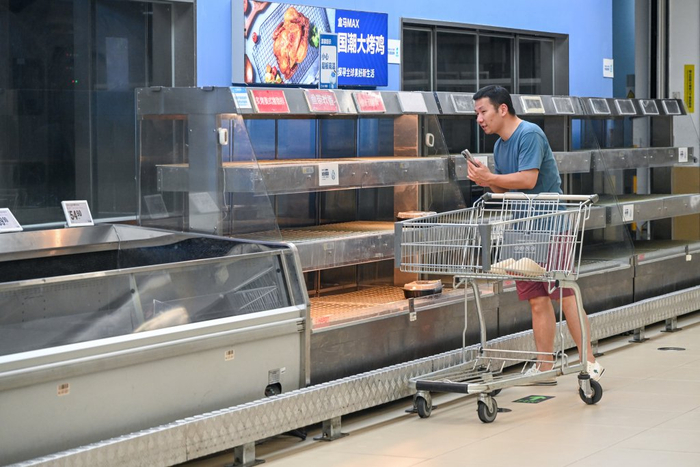 李先生在熟食区一边和家人视频一边闲逛。