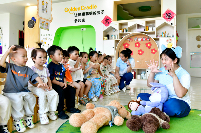 ▲7月22日，在博兴县金色摇篮幼儿园，老师带托育班的孩子做游戏。图/新华社