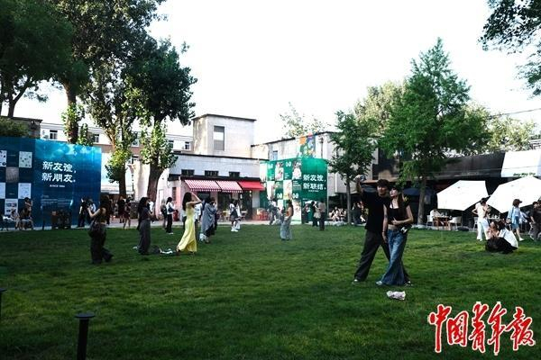 8月3日，北京友谊商店，顾客在草坪上拍照。焦晶娴/摄