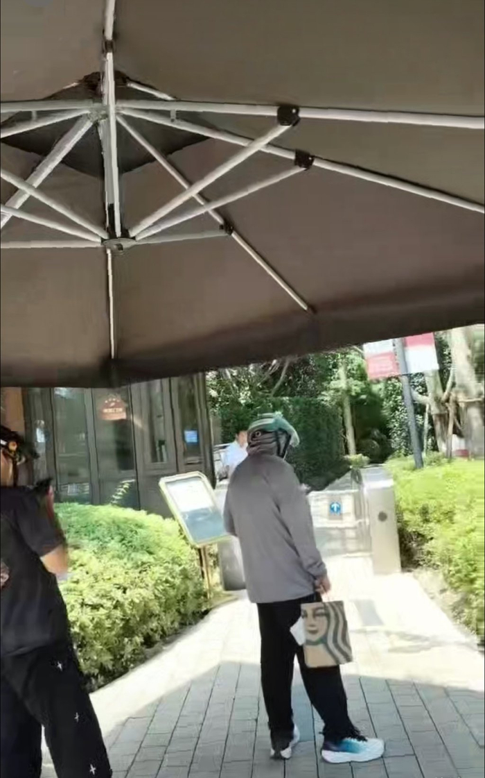 此前，有配送员拎着外卖餐盒在小区门口等待。受访外卖骑手供图