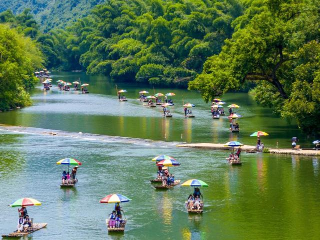 7月31日，游客在广西桂林市阳朔县遇龙河乘坐竹筏漂流（无人机照片）。新华社发（何华文摄）