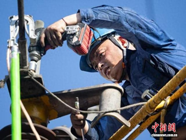 高温天气下电力抢修人员处理设备故障。曹颀 摄