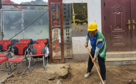 8月2日，孙胡沟村村委会前，救援人员在清理泥沙。新京报记者 周怀宗 摄