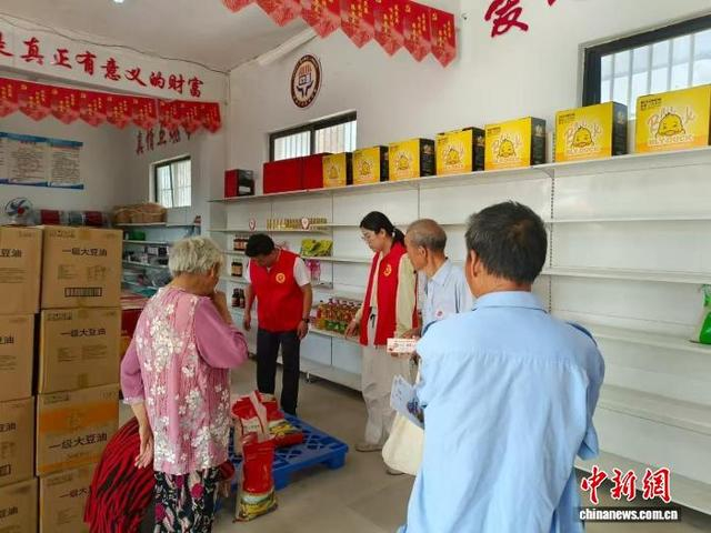 图为村民拿着积分券到爱心超市兑换物品。王莹莹 摄