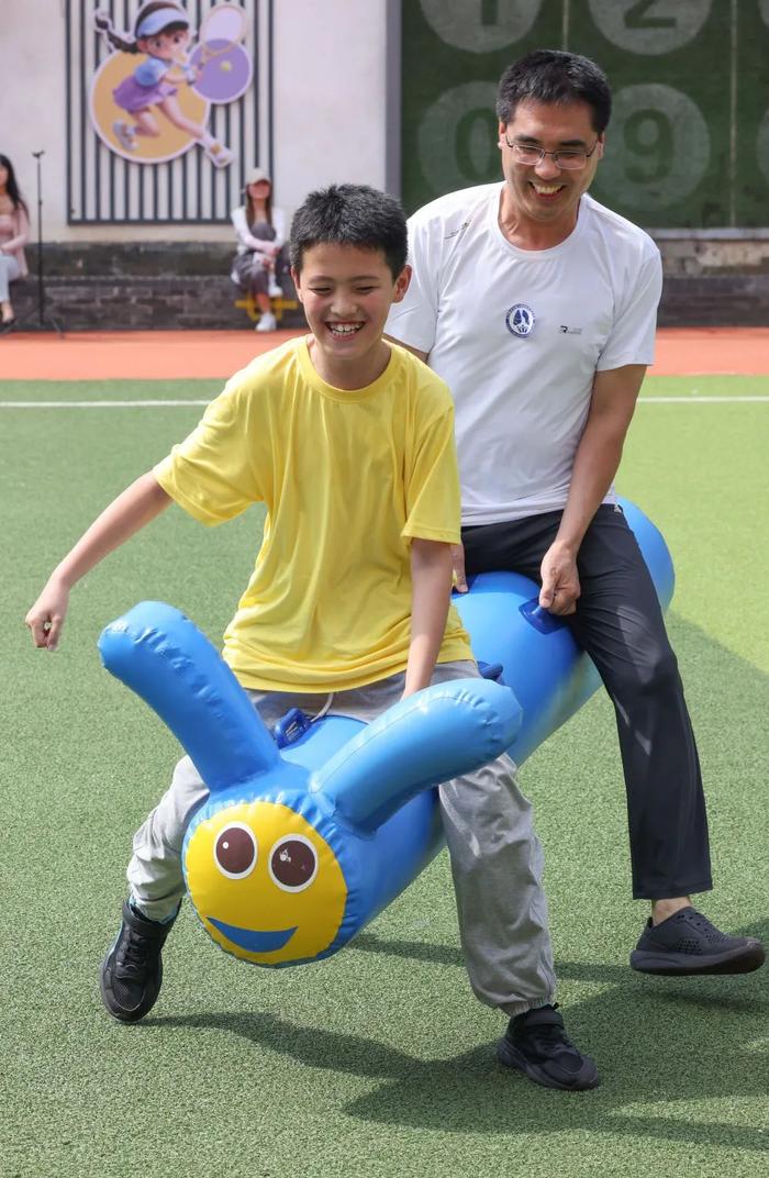 7月5日,在北京举行的一个亲子活动中,家长和孩子合作进行“大青虫往返跑”比赛。新华社记者 殷刚 摄