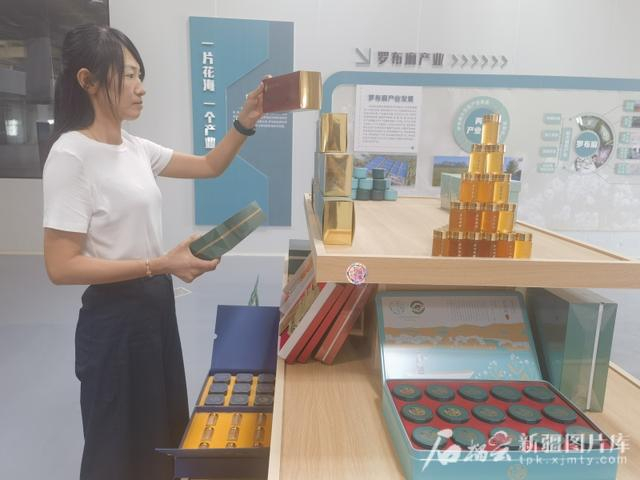 7月16日，在尉犁县罗布麻茶蜜有限公司的展厅里，工作人员整理罗布麻茶蜜产品。汪志鹏摄