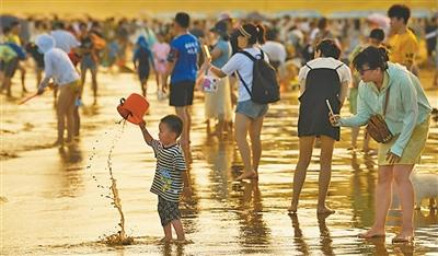 浙江舟山市朱家尖南沙景区，游客在沙滩上游玩。姚凯乐摄