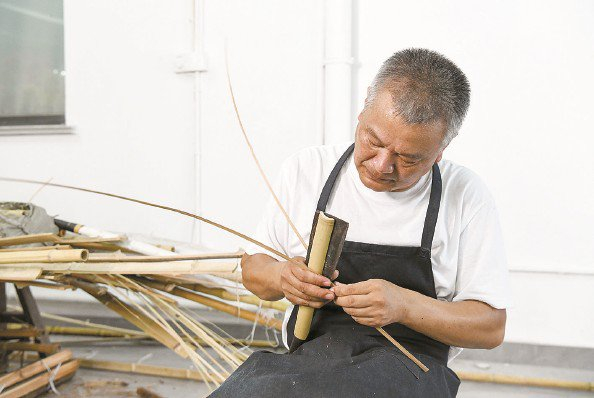             叶榭镇非遗竹编传承工作室的师傅在编草龙          