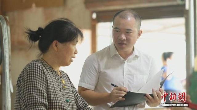 安仁产业开发区副主任谭志鹏走访记录伍金花工作情况和身体状况。安仁县委宣传部供图