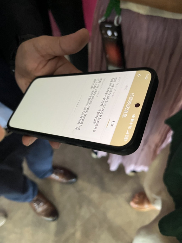 悦江（上海）餐饮发展有限公司总经理杨明向记者展示其手机收到的行政信息。 澎湃新闻记者 邹娟 摄