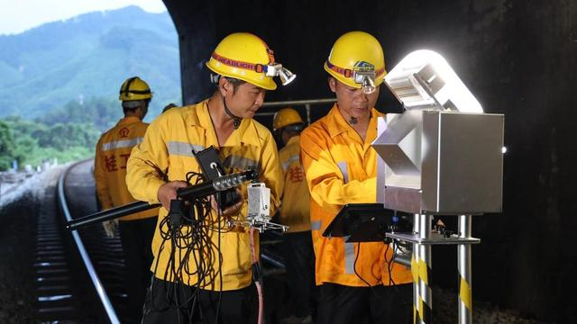 在湘桂铁路（广西段）沿线，桥隧工人检查隧道内铁轨（7月16日摄）。新华社记者 张爱林 摄