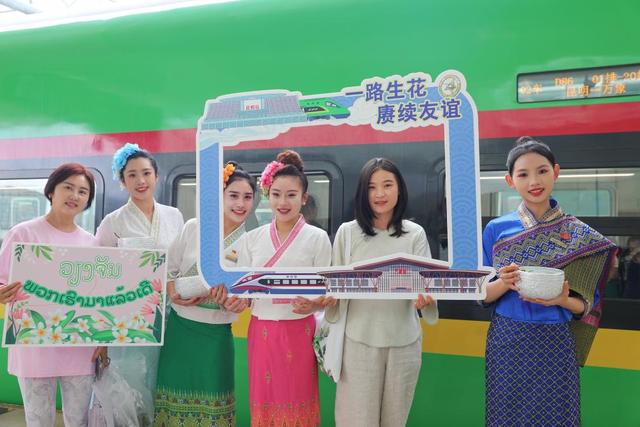 7月18日，在昆明站，乘坐昆明至万象D86次列车的乘客与乘务员合影。新华社发（杨紫轩摄）