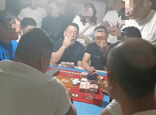 汤恕与人聚众赌博的视频截图，坐在中间戴着眼镜的男子为汤恕。 受访者供图