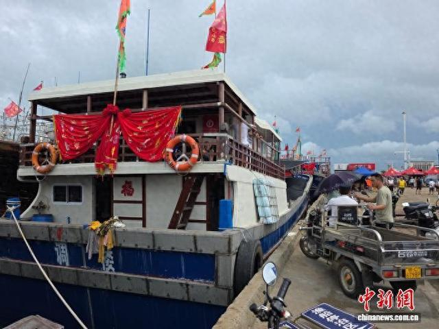 8月16日，海南省临高县武莲渔港，渔民们往船上运送物资。中新社记者 王晓斌 摄
