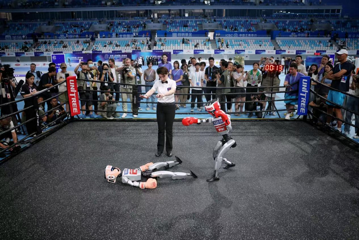 自由搏击项目比赛现场，奥林1队队员薛明控制机器人击倒对手 新京报记者薛珺/摄