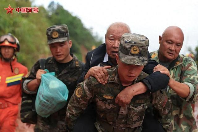 武警官兵帮助受灾群众转移 叶胡安摄