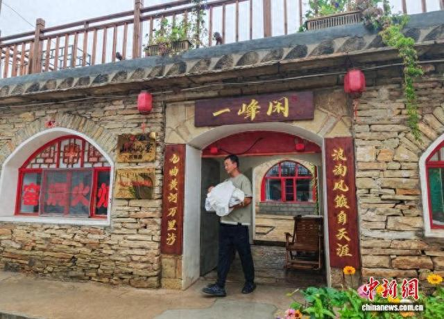 李俊峰在自家民宿忙碌。 中新网记者 刘文华 摄