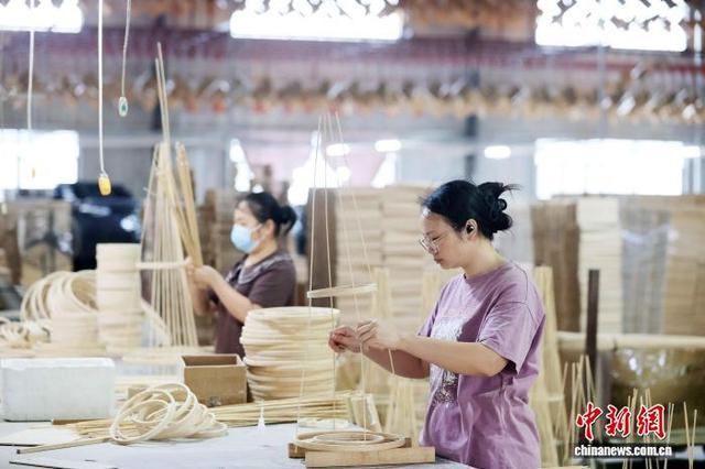 图为工人在生产线上紧张地忙碌，赶制国外订单。谭凯兴 摄