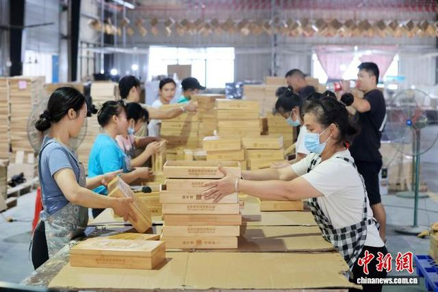 图为工人在生产线上紧张地忙碌，赶制国外订单。谭凯兴 摄
