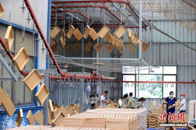 图为工人在生产线上紧张地忙碌，赶制国外订单。谭凯兴 摄