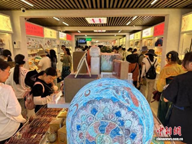 8月8日，游客在敦煌研究院文化创意馆购买文创产品。中新社记者 冯志军 摄