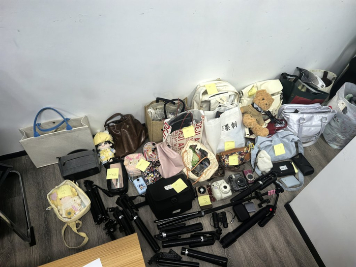 成堆的相机、背包和演出物料堆放在派出所内。受访者供图