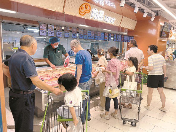             上午，百联西郊购物中心的清美“品上生活”自营超市内，顾客正在选购肉品和水产品  本报记者  周馨  摄          