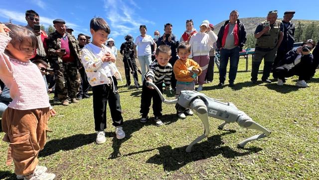 科普大篷车开进新疆阿勒泰青河县套查干湖夏牧场,当地小朋友和机器狗互动。(新疆科技馆供图)