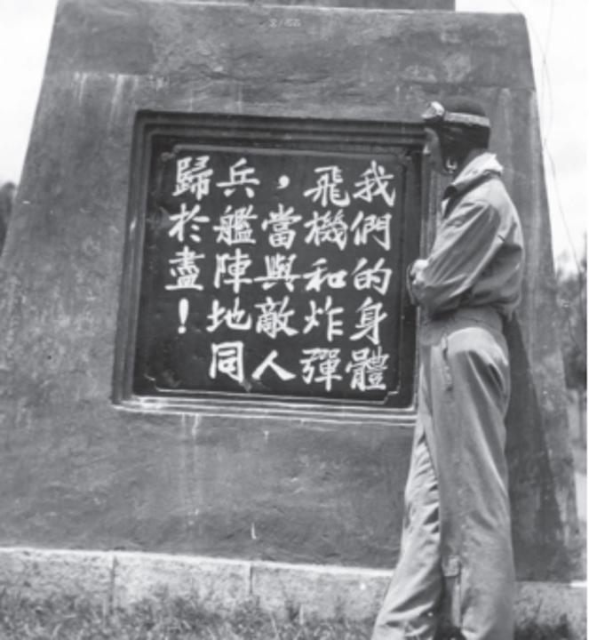 航校学员与刻有中央航校校训的石碑合影(王国平 供图)