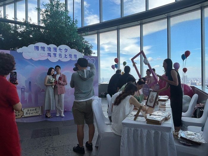8月29日，新人在上海中心特色登记点打卡、体验宋锦绘制。