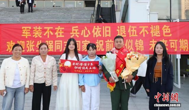 9月1日,青海西宁,武警青海总队一名退伍老兵(右二)与亲友在西宁火车站合影。中新社记者 马铭言 摄