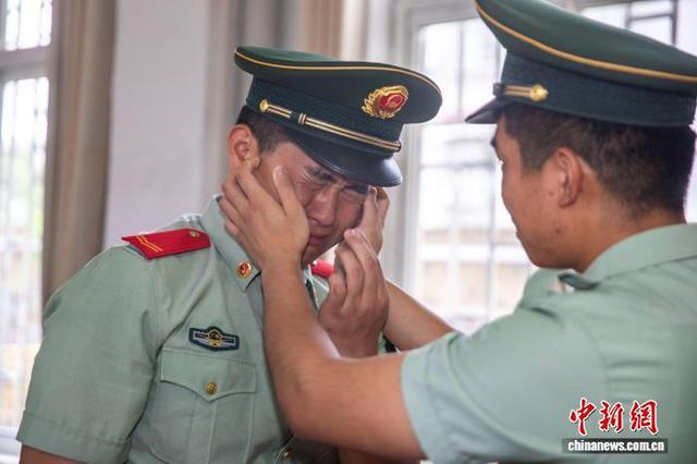 图为退役老兵依依不舍告别战友。施晨洲 摄