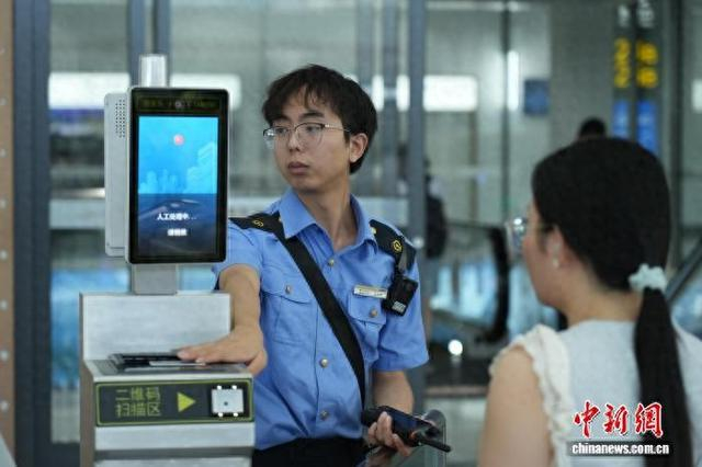 图为重庆东站工作人员为乘客检票。魏伟 摄