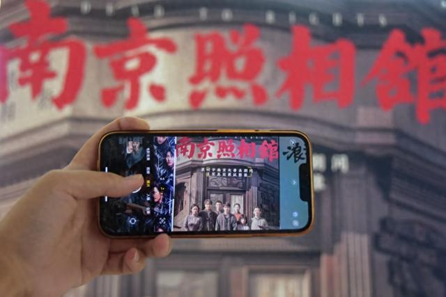 8月9日，在云南省蒙自市一电影院，观众在拍摄影片海报。新华社发（薛莹莹摄）
