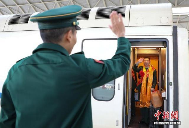 9月1日,青海西宁,武警青海总队机动某支队一名退伍老兵在列车车厢内向战友挥手告别。中新社记者 马铭言 摄