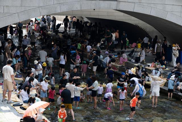 6月14日,人们在韩国首尔的清溪川戏水。新华社发(全休相摄)