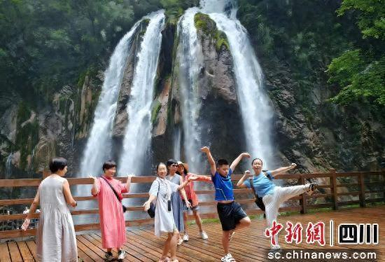 游客在虎牙大龙口瀑布打卡拍照。 平武县委宣传部供图