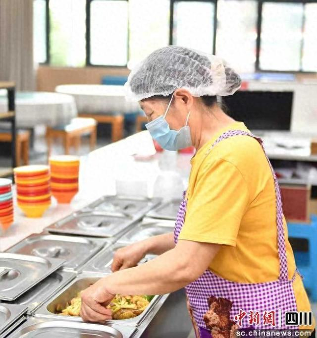 食堂工作人员正在准备菜品。庞圆斌 摄