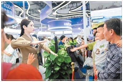 观众在博览会现场与一款智能机器人互动。新华社记者 赵宇思摄