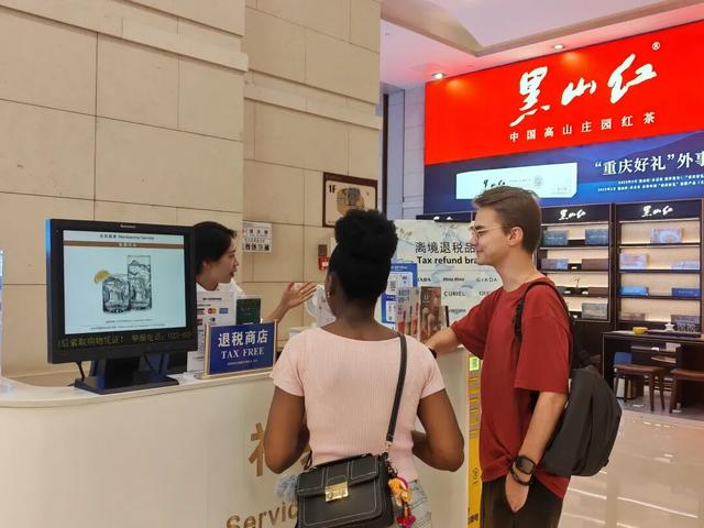 图为在解放碑的重庆环球金融中心离境退税服务台，工作人员为来自俄罗斯和西非多哥的游客介绍离境退税“即买即退”服务。