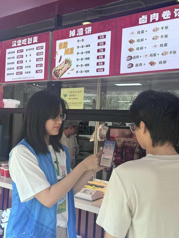 首都师范大学良乡校区内，志愿者向同学讲解“新生畅享计划”。良乡大学城管委会供图