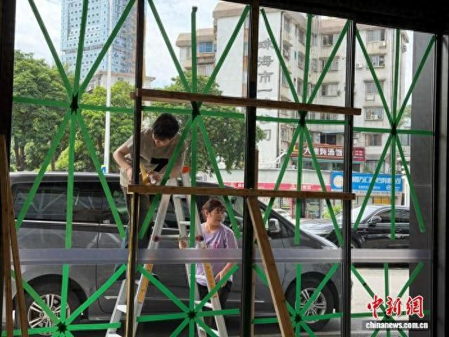 9月23日，珠海一酒店的工作人员在加固门窗防御台风。王坚 摄